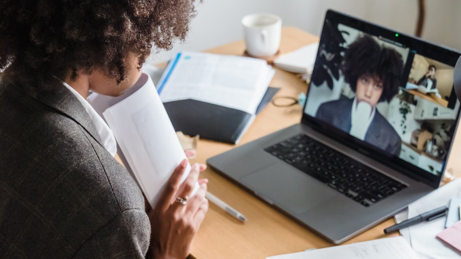 A young woman leading a video call from a bright modern office.