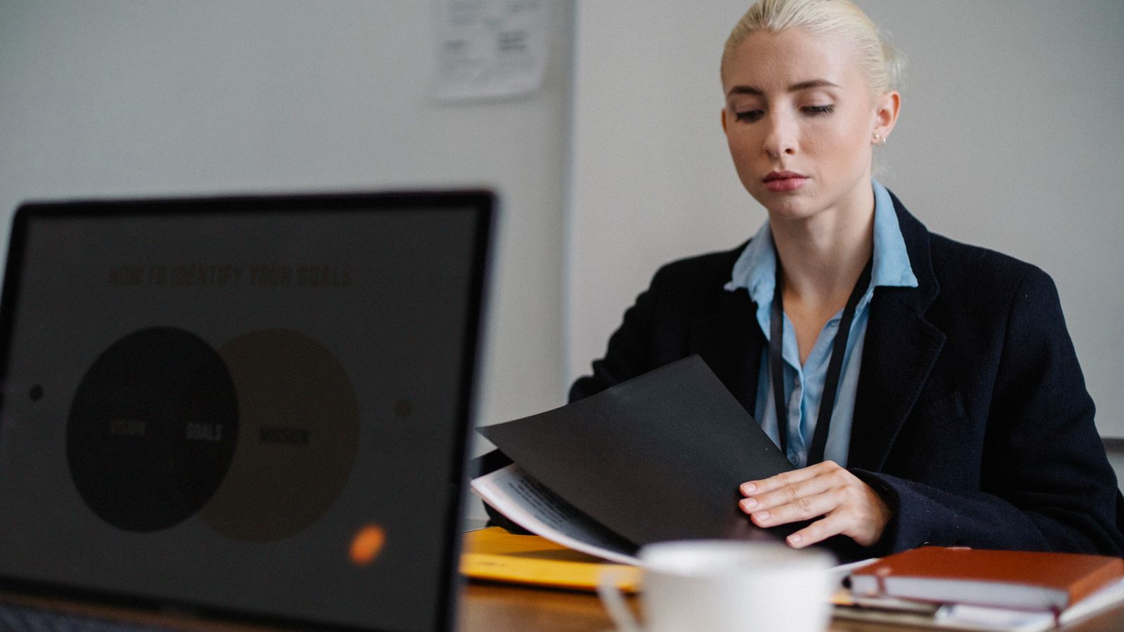 A young professional woman taking notes during a team meeting.
