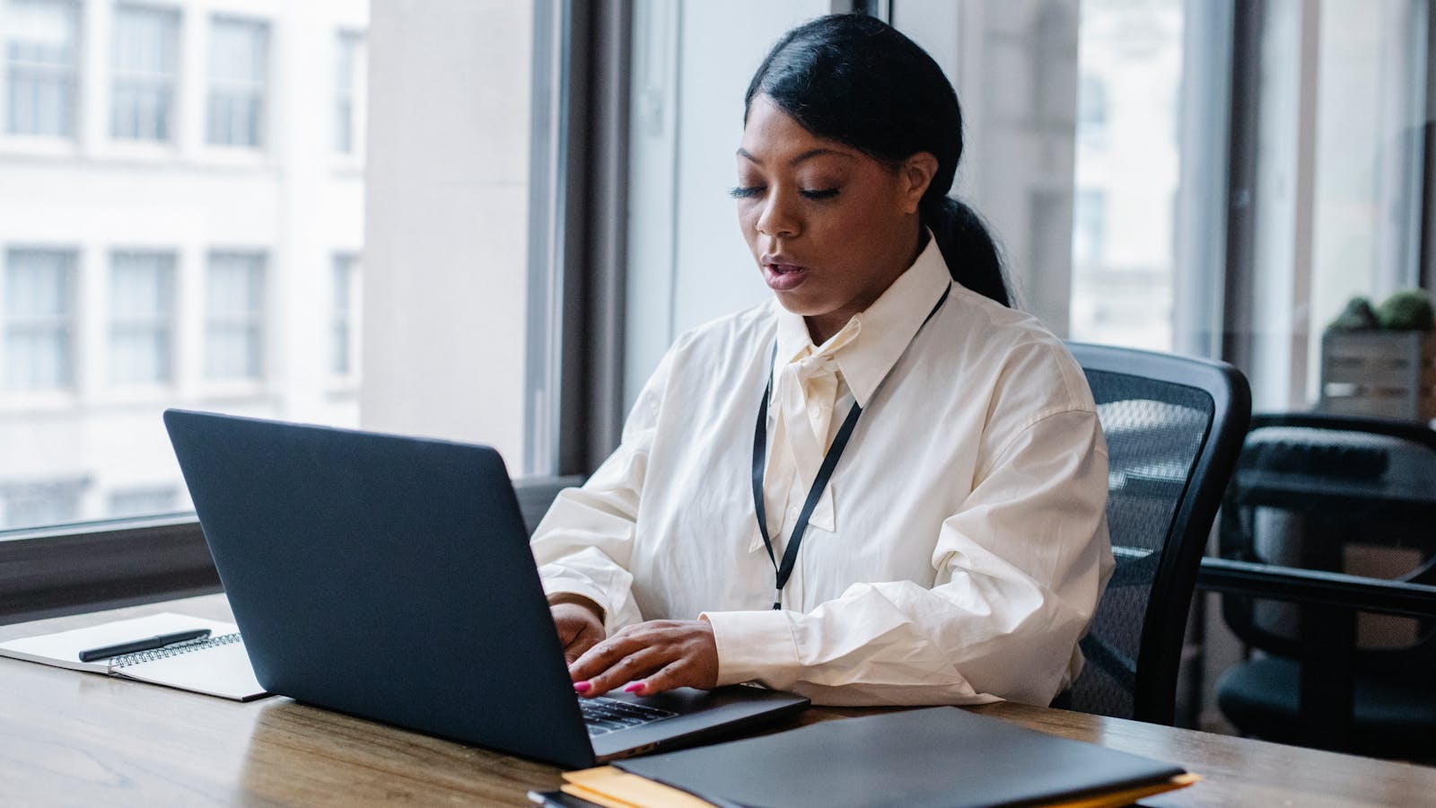 A young woman leading a video call from a bright modern office.