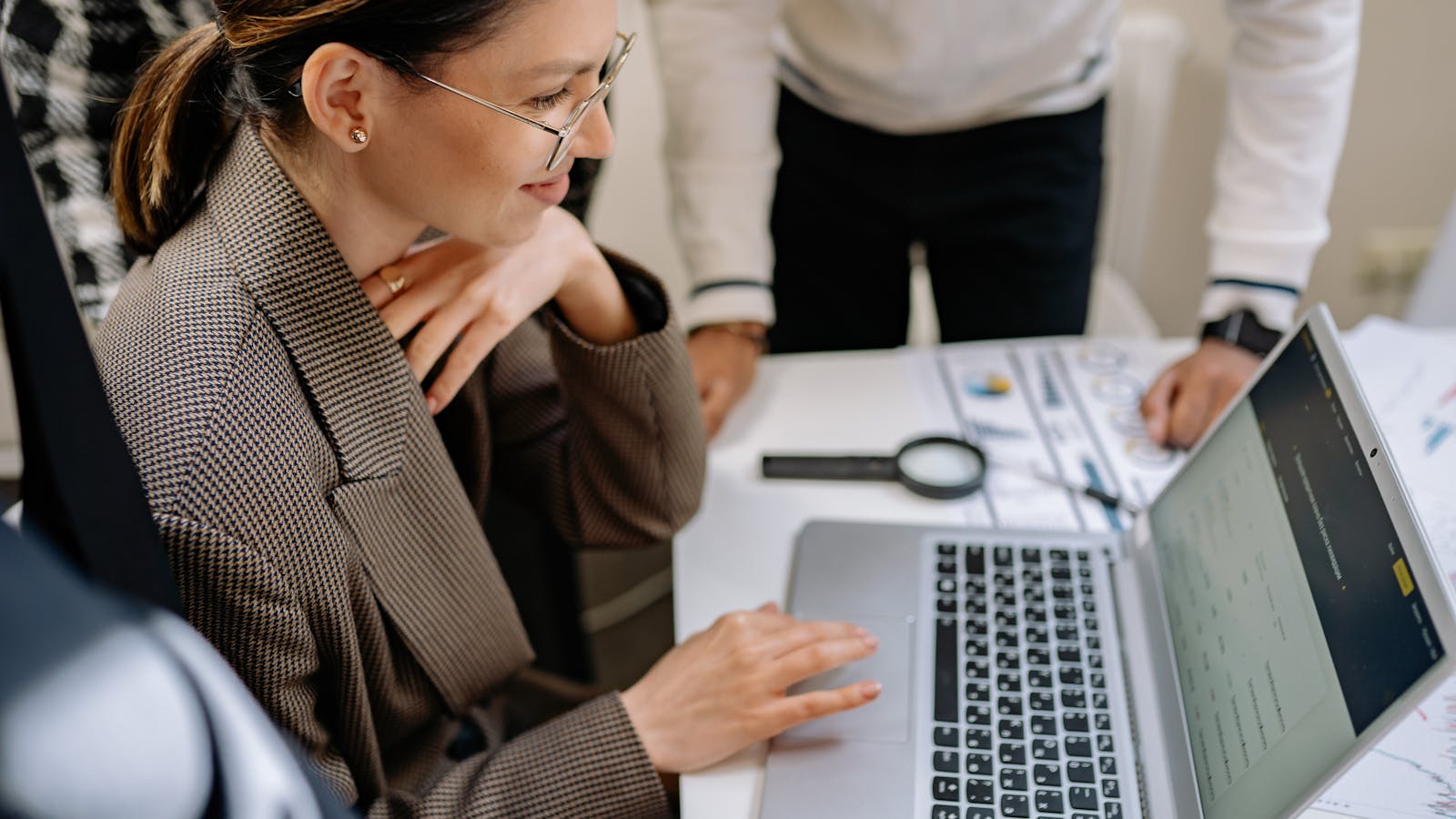 A young woman presenting to coworkers around an office table.