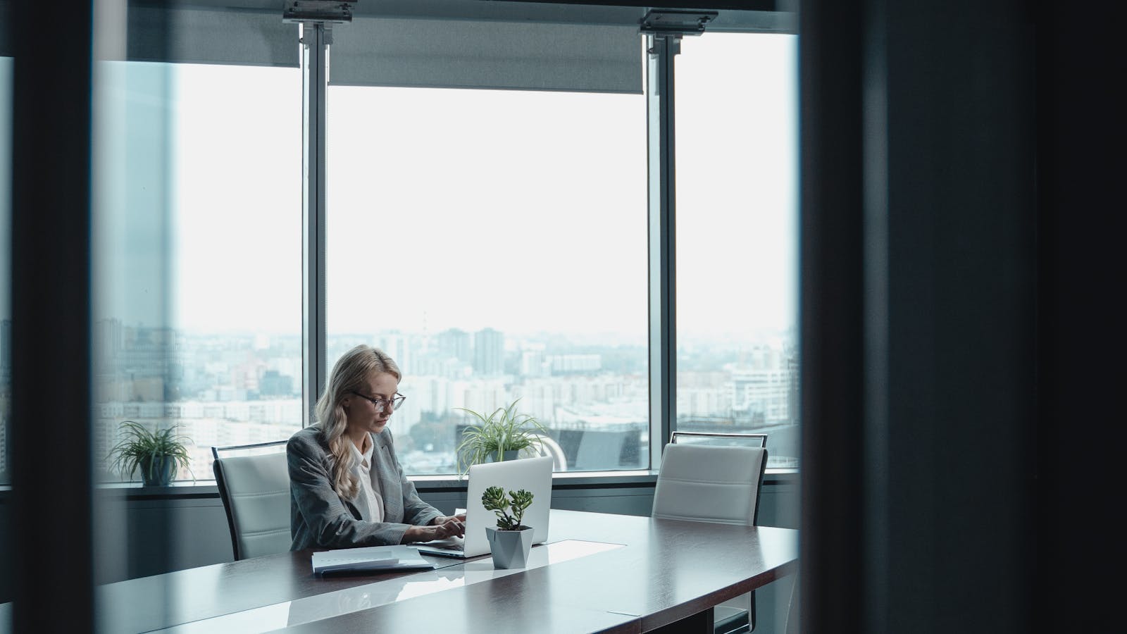 A young woman leading a video call from a bright modern office.