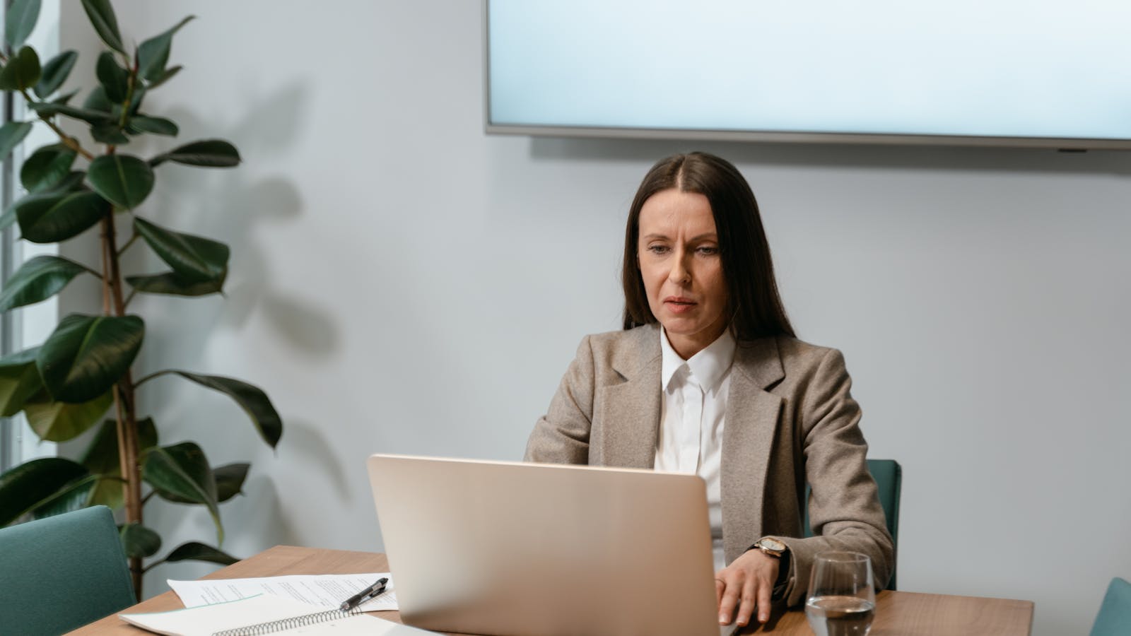 A young professional woman collaborating with colleagues in a meeting room.