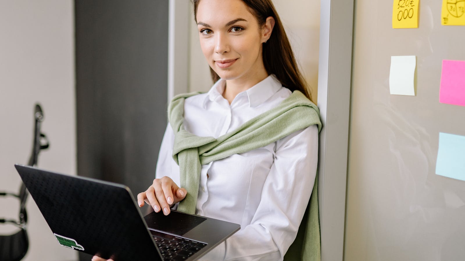 A young woman presenting to coworkers around an office table.